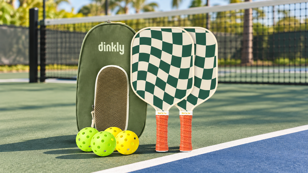 Dinkly Play two-paddle set with green bag and pickleballs on court