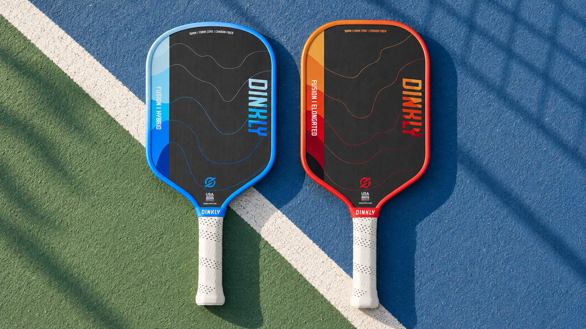 Blue Dinkly Fusion Hybrid and red Dinkly Fusion Elongated paddles on court